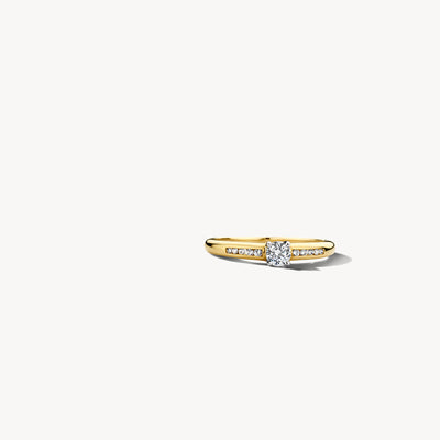 Bague étroite en or jaune et blanc 14k avec zircone centrale et pierres d'accentuation sur les côtés.