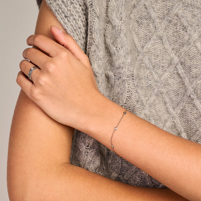 Dunne armband van 14k wit goud met subtiele zirkonia schakels op pols.