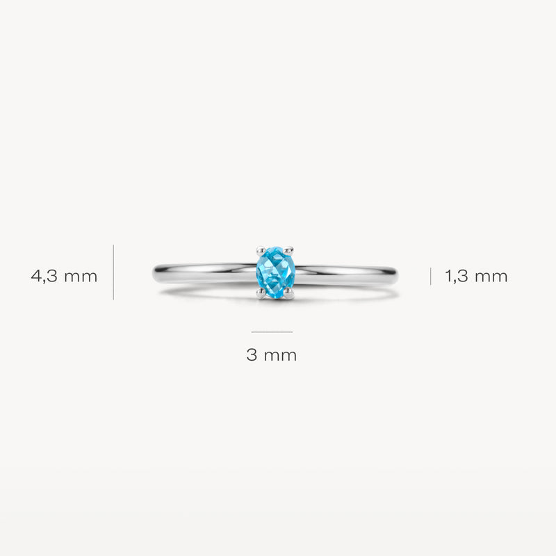 Dunne ring van 14k wit goud met kleine ovale blauwe topaassteen, 3 mm breed.