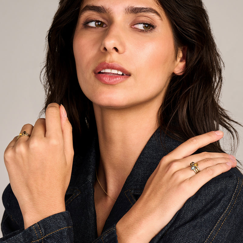 Solitair ring van 14k geelgoud met ronde citrien in vrouwelijke hand naast gezicht.