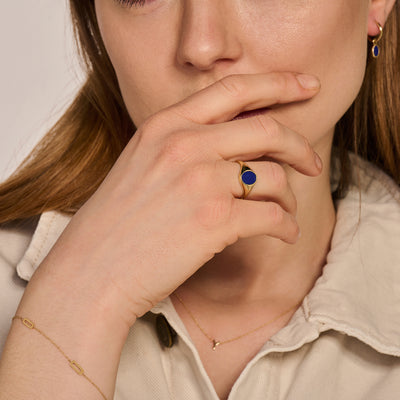 585er Siegelring aus Gelbgold mit rundem lapisblauem Stein am schlanken Finger.