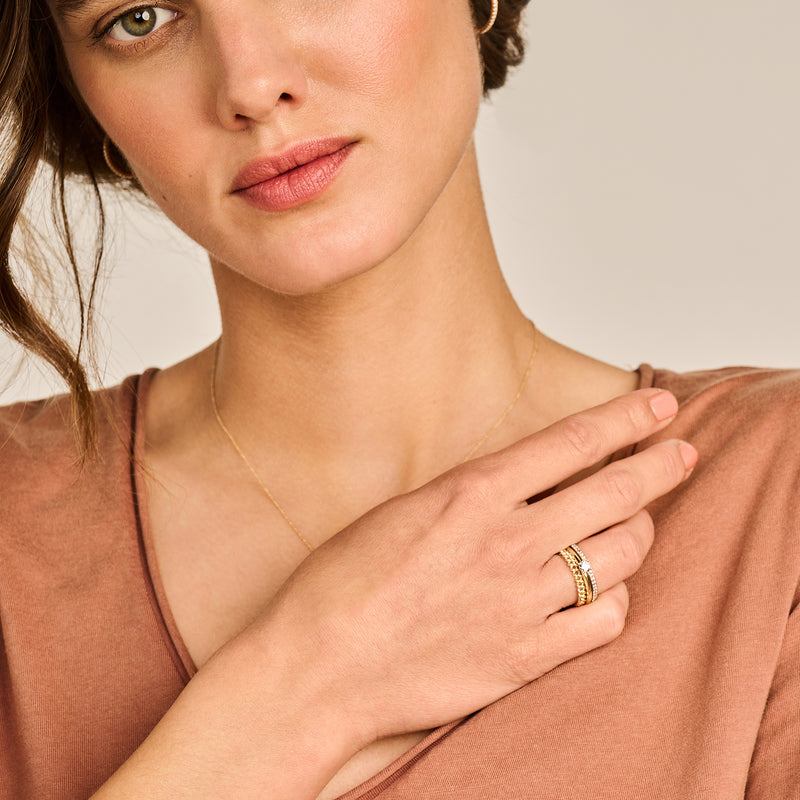 Bicolor goud ring met 14k geelgoud en wit goud, breed model op vinger van vrouw.