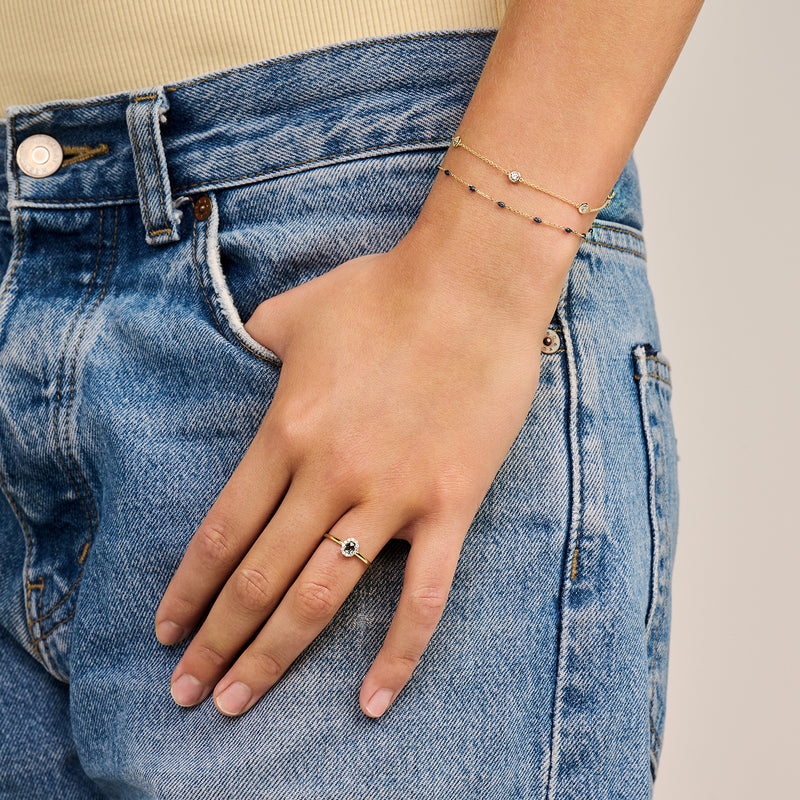 Dunne bicolor goud armband met fijne schakels en kleine zirkonia op pols.