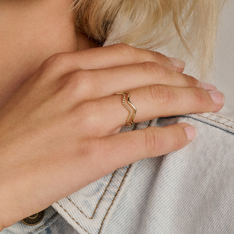 14k geelgouden ring met golvende, smalle band in goudstijl.