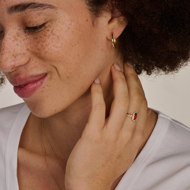 14k bicolor goud ring met rode zirkonia op wijsvinger, subtiel en verfijnd design.