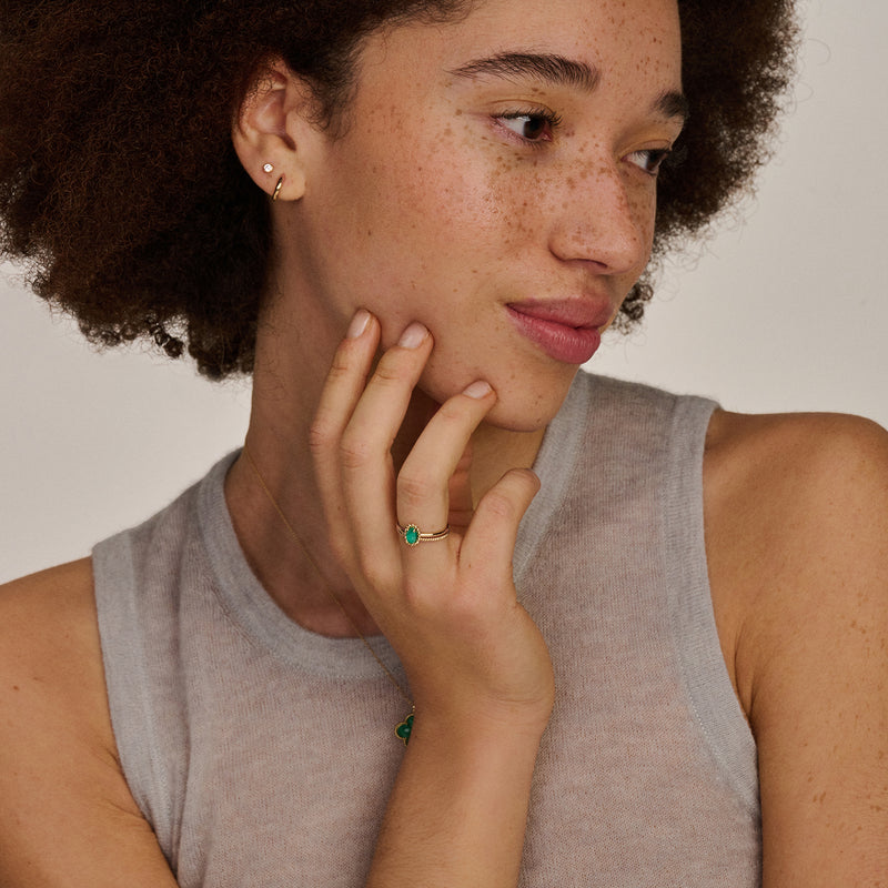 14k geelgouden oorknop met fonkelende zirkonia subtiel gedragen door vrouw.