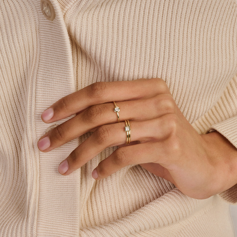 Bicolor 14k goud aanschuifring met zirkonia op gestapelde vingers.