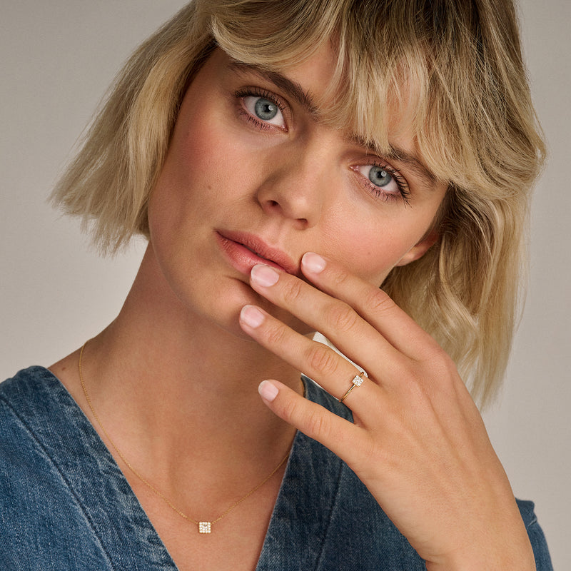 Bague en or 14k avec petits zircones, portée à l'index, subtile et sophistiquée.