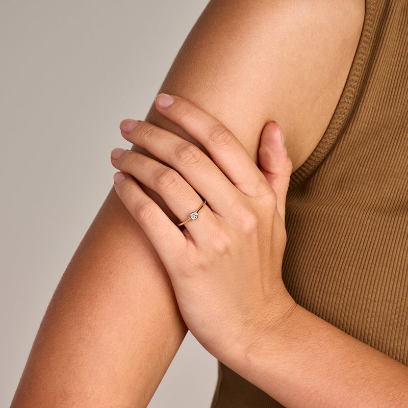 Bicolor ring met 14k wit goud en geel goud en een ronde diamant, gedragen op hand.