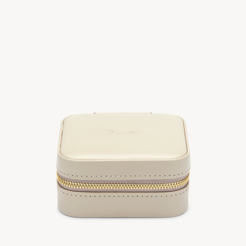 Kompaktes, graues Schmucketui mit goldfarbenem Reißverschluss und dezenten Nähten.