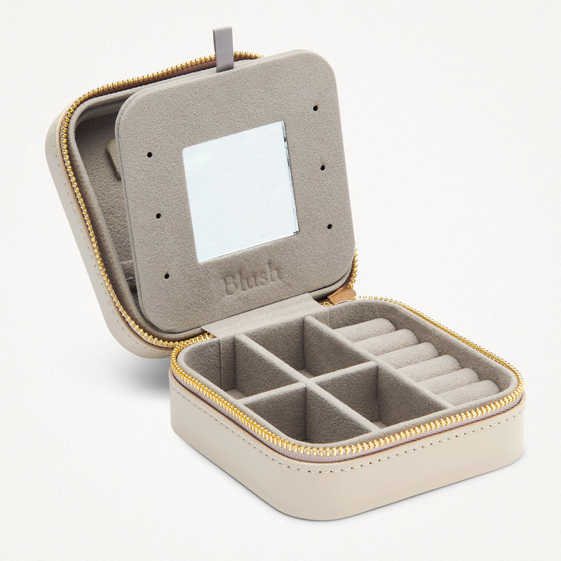 Beigefarbenes Schmuckreiseetui mit Reißverschluss, Fächern für Ringe und Fächer, weiches Innenfutter.