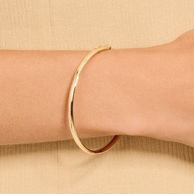 Slanke bangle armband van 14k goud met een gladde glanzende afwerking.