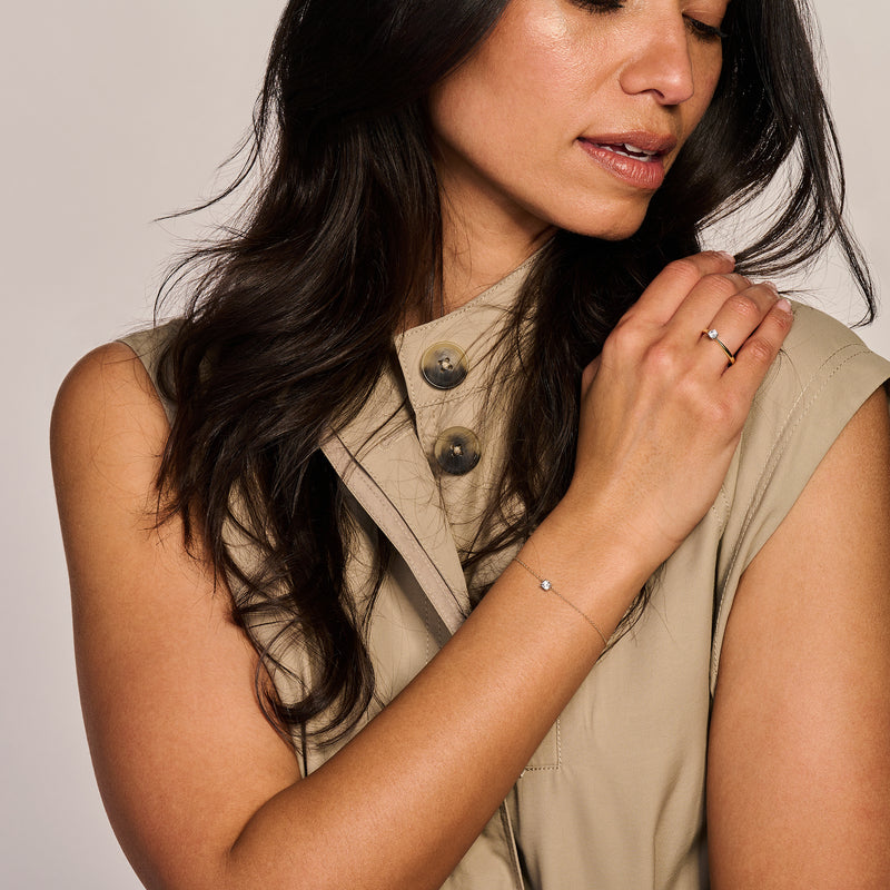 Slanke armband van 14k goud en wit goud met kleine zirkonia accenten aan damespols.