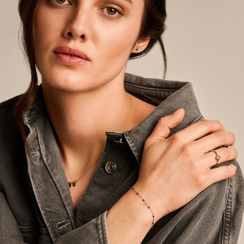 Fijne 14k geelgouden armband met subtiele blauwe resin schakels.