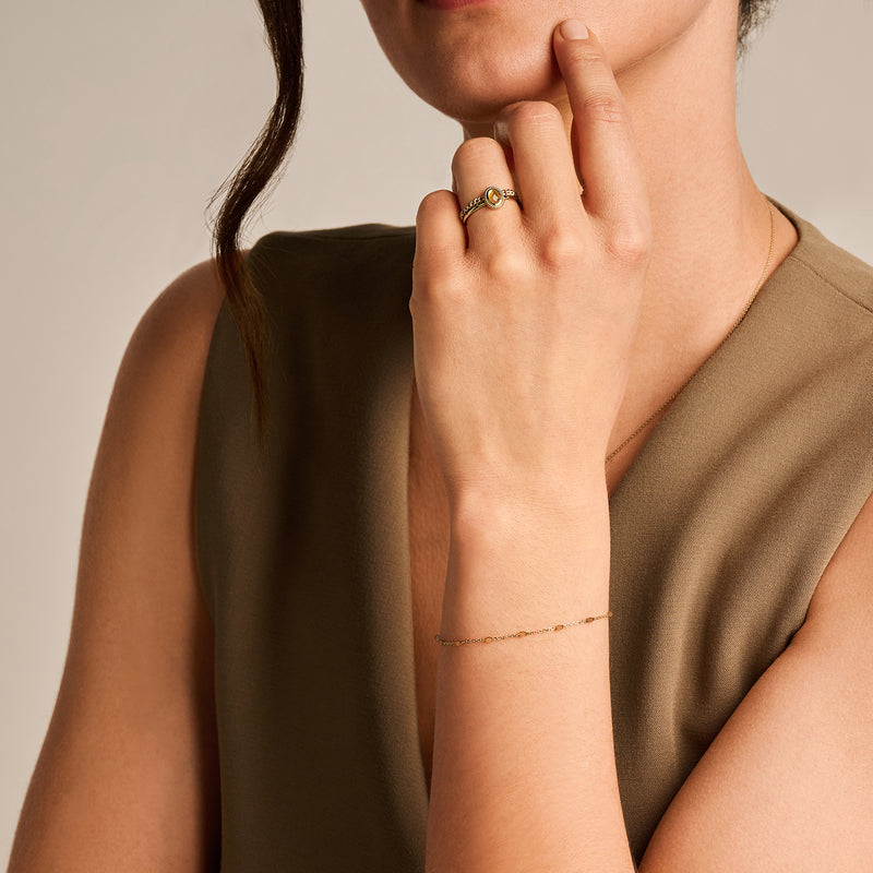 Armband van 14k geelgoud met fijne schakels en caramelkleurige resin accent.