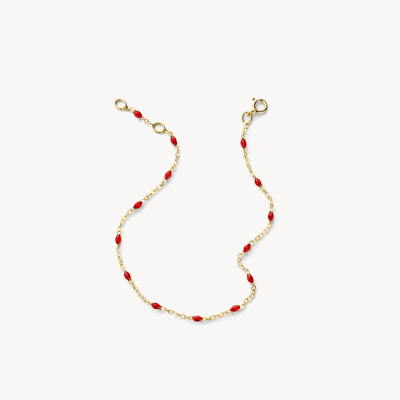 Bracelet composé de maillons en or fin 14k et de petites perles en résine rouge.