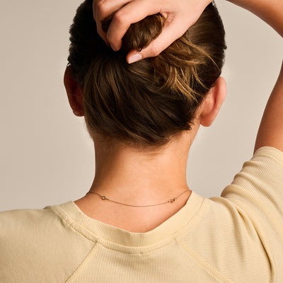 Fijn ketting verlengstukje in 14k goud, subtiel en smal, gedragen achter de nek.