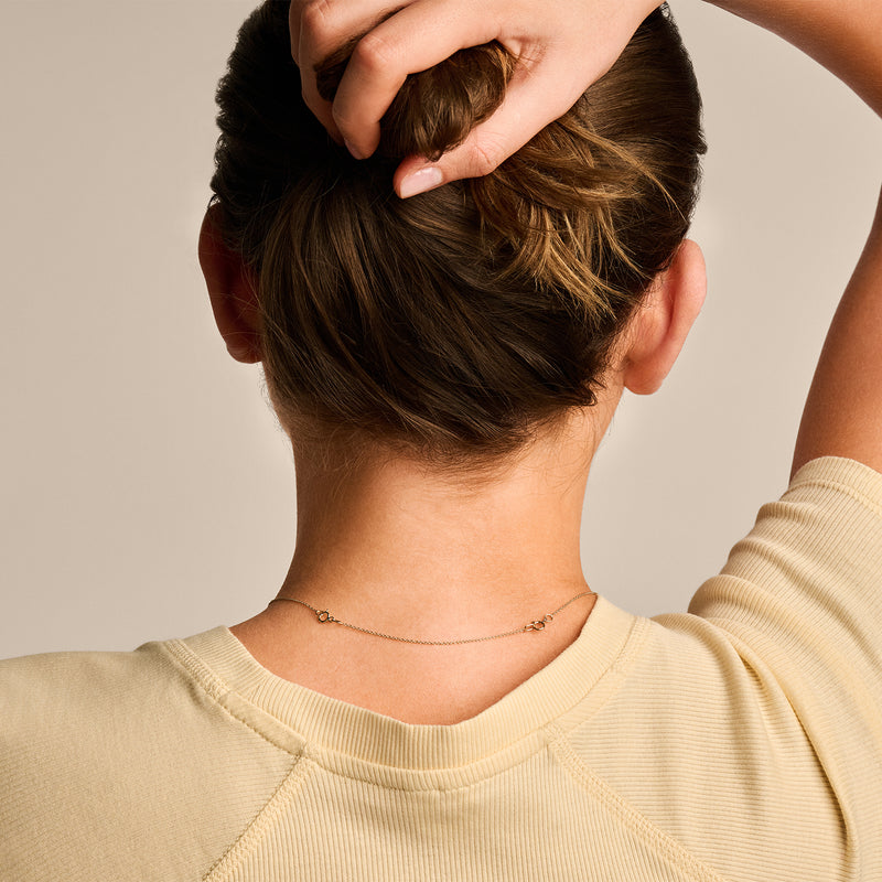 Fijn ketting verlengstukje in 14k goud, subtiel en smal, gedragen achter de nek.