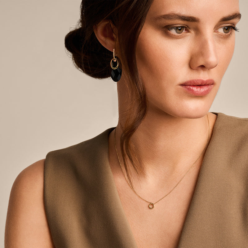 Fijne ketting van 14k geelgoud met klein rond hangertje naast het sleutelbeen.