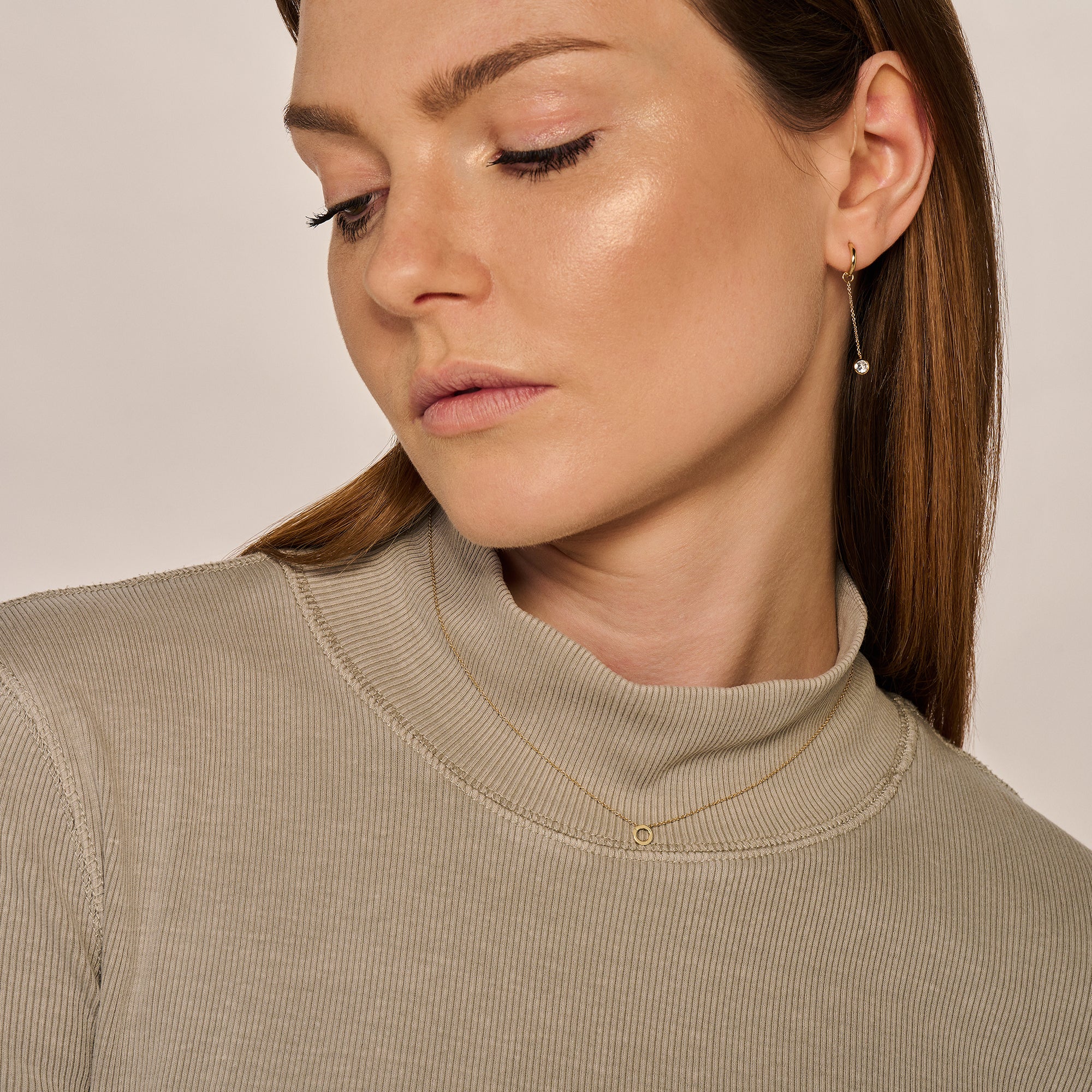 Fijne ketting van 14k geelgoud met kleine schakels, gedragen door vrouw.