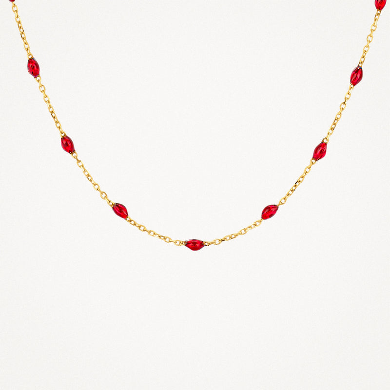Collier en or jaune 14k avec des maillons fins et des petites perles en résine rouge.