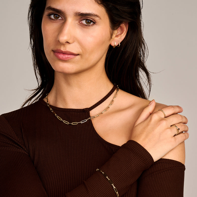 14k geelgoud grove schakelarmband om pols met bijpassende ring en oorbellen.