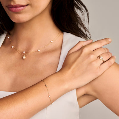 Dunne armband van 14k geel goud met kleine zirkonia schakels in bicolor goud op de pols.