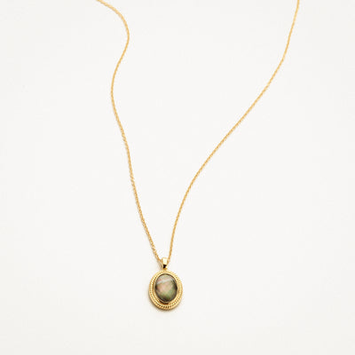14k yellow gold necklace with oval pendant of black mother of pearl and rock crystal.