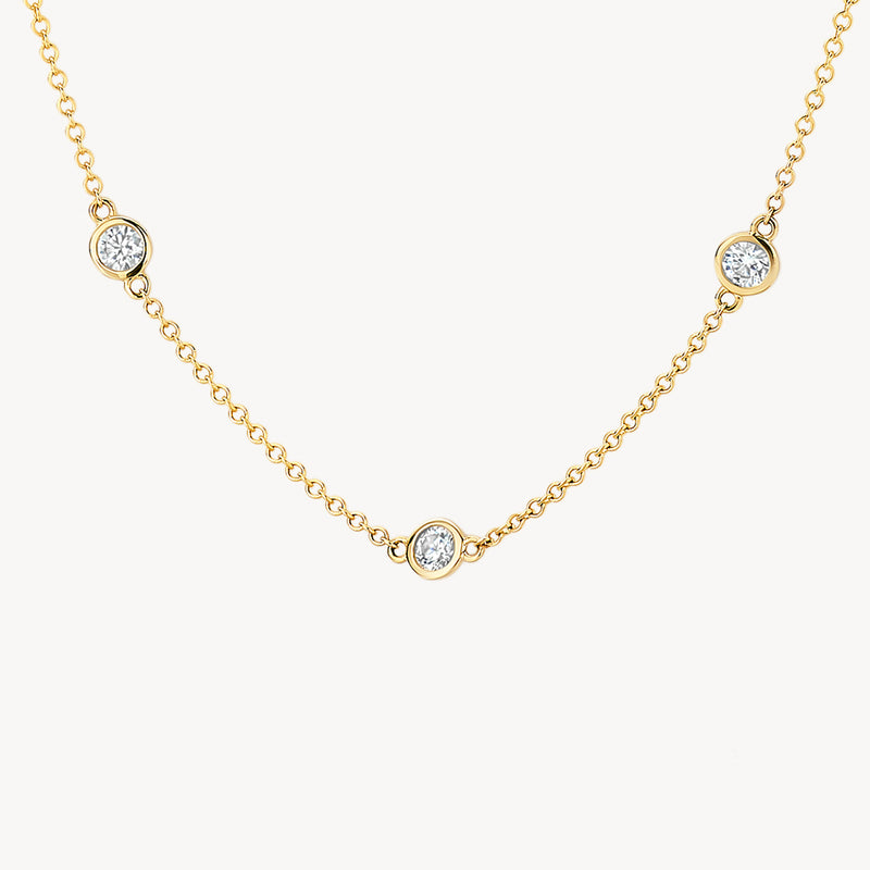 Fijne schakels van 14k geelgoud met drie fonkelende zirkonia stenen op ketting.