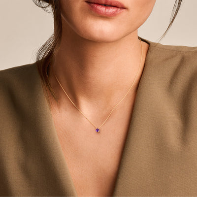 14k geel goud ketting met kleine amethist hanger aan fijne schakelketting.