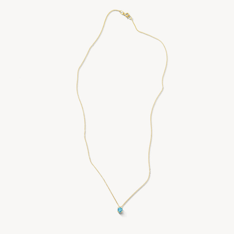 Collier en or jaune 14k avec petit pendentif en topaze bleue et maillons fins.