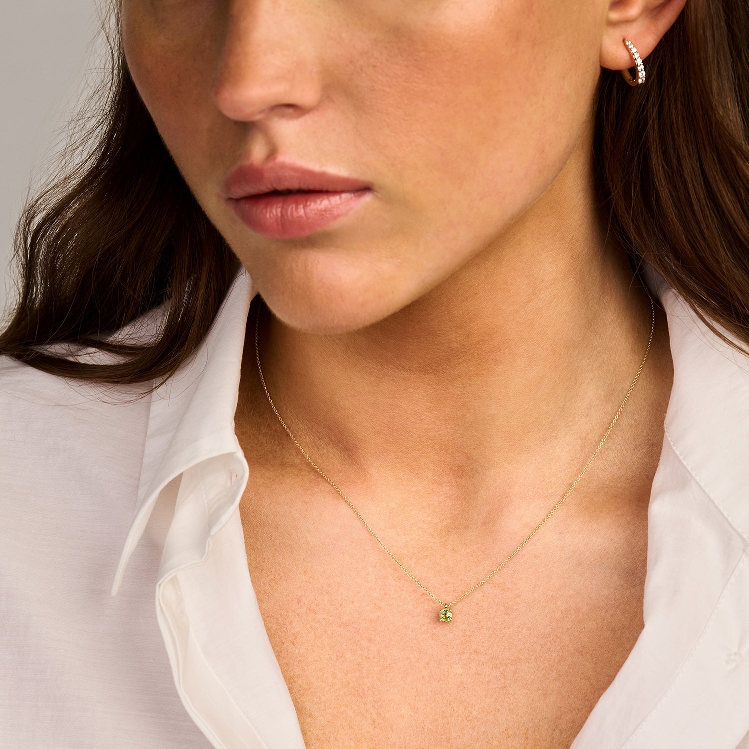 14k goud ketting met klein peridot bedel aan dunne ketting.