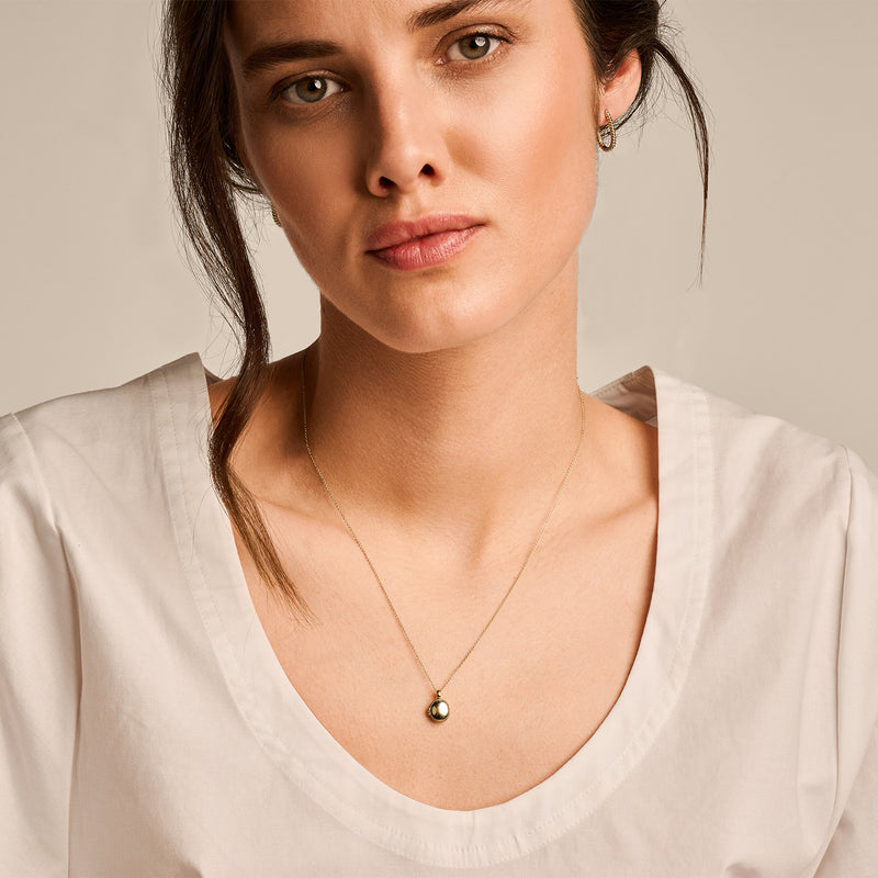 Bicolor gouden medaillon hanger aan dunne 14k goud ketting, rond en gepolijst.