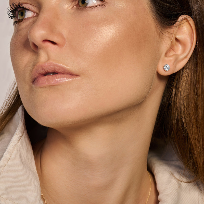 Oorknop 14k wit goud met ronde zirkonia in zilverkleurige zetting, gedragen in oorlel.