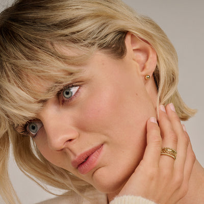 14k geelgouden oorknopjes en vier ringen, samen gestyled.
