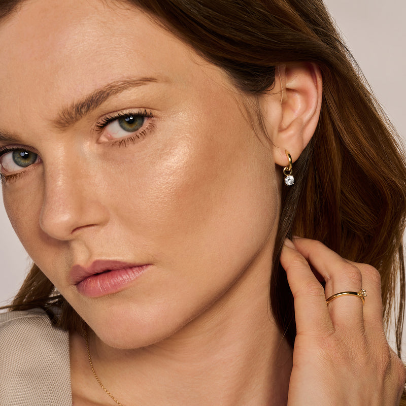 14k goud oorringen met kleine hanger en witte steen, bicolor goud details.