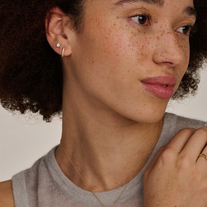 Kleine oorringen van 14k geelgoud met gecentreerde zirkonia voor subtiele sparkle.