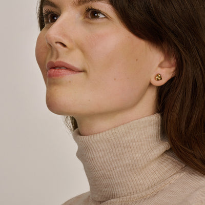 Oorknopjes van 14k geelgoud, rond en glanzend, subtiel aan oorlel gedragen.