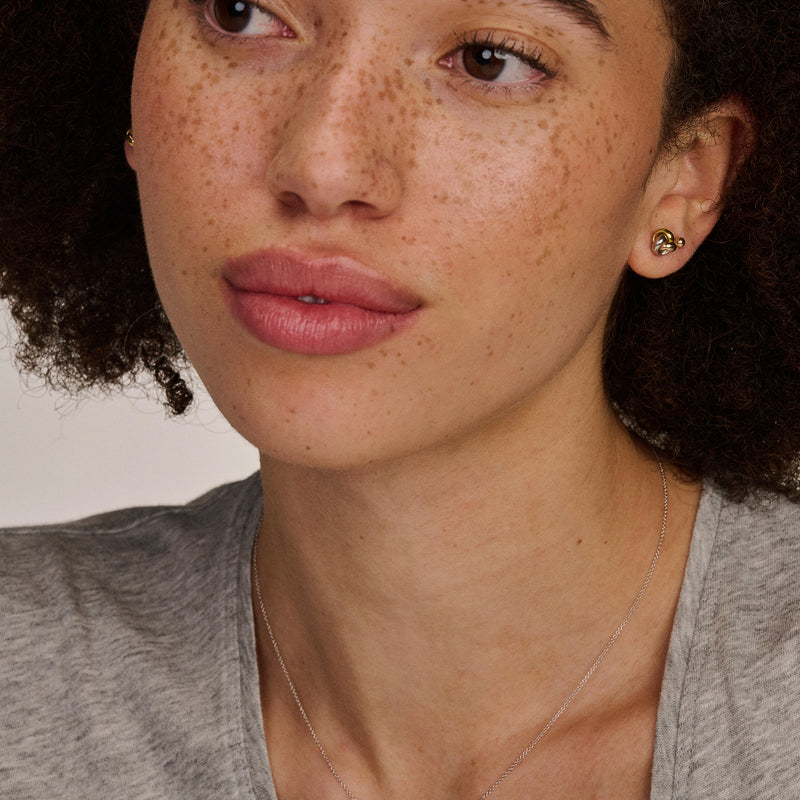 Clous d'oreilles bicolores en or blanc 14k et en or rose 14k, au design détaillé et sophistiqué.