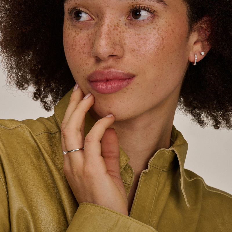 Oorknopjes van 14k wit goud met kleine fonkelende zirkonia, bicolor gouddetail zichtbaar.