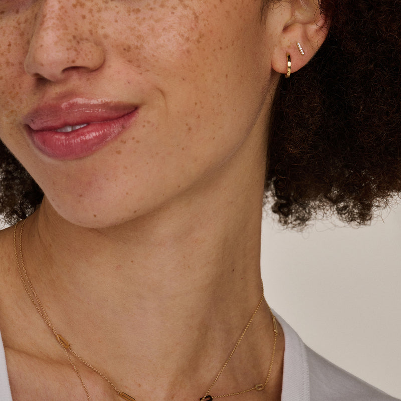 14k geelgouden oorknoppen met fonkelende zirkonia details, subtiel design.