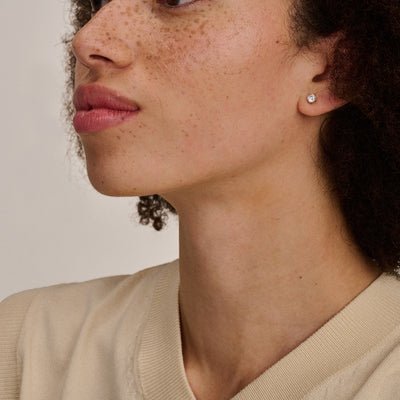 Oorknopje van 14k wit goud met subtiele glans, klein en rond.