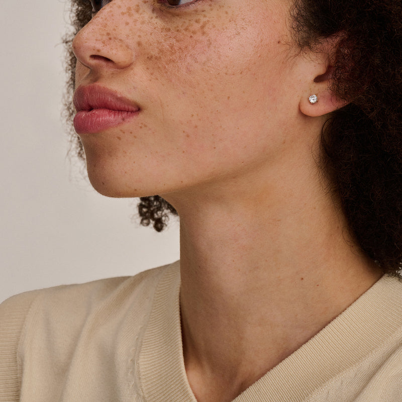 Oorknopje van 14k wit goud met subtiele glans, klein en rond.