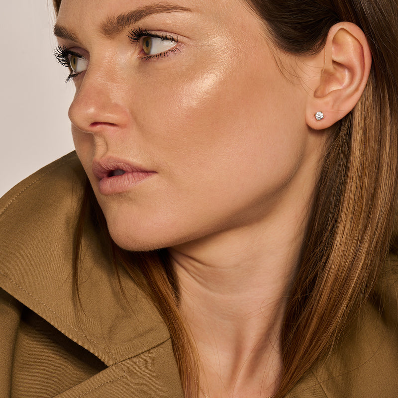 Oorknop van 14k geelgoud met fonkelende diamantdetail in oor van vrouw.