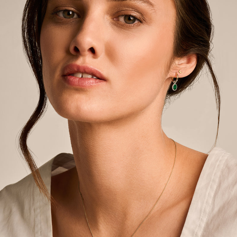 14k geelgouden oorringen met gedraaide textuur en groene edelsteen.