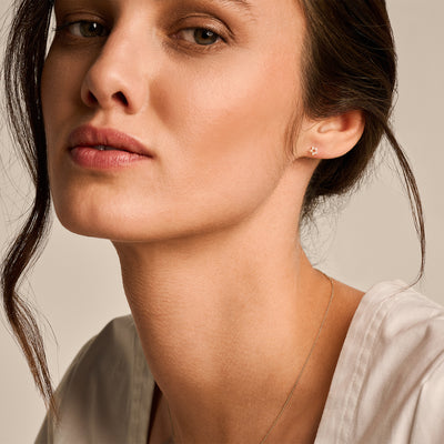 Oorknopjes van 14k geelgoud subtiel gedragen aan oorlel.