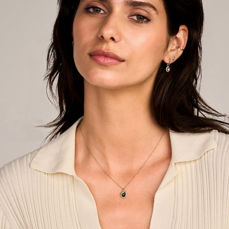 14k geelgouden oorbellen met zwarte parelmoer doublette en rock crystal details.