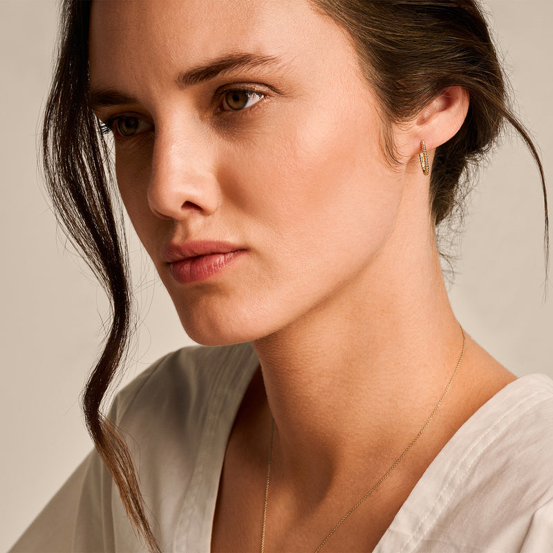 Oorring van 14k geel goud, klein en rond, subtiel glanzend en fijn afgewerkt.