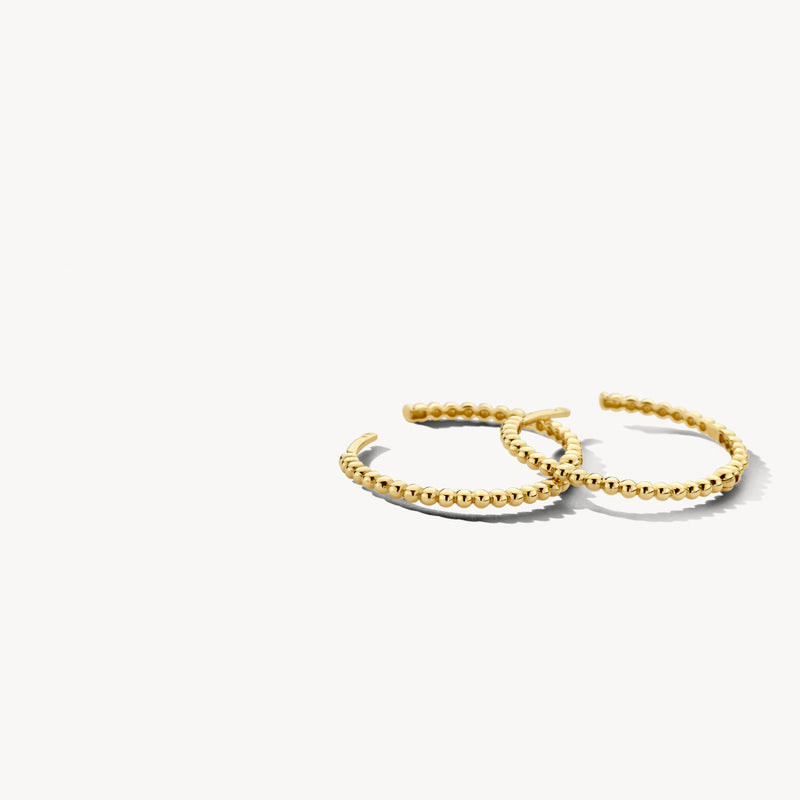 Anneaux d'oreilles d'or bicolore avec de l'or jaune 14k et de l'or blanc 14k dans un design torsadé.