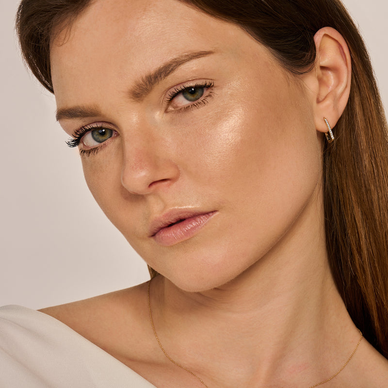 14k geelgouden oorringen met kleine zirkonia, subtiele glans en gladde afwerking.